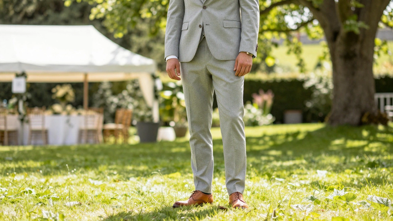 A man in a light grey suit at a summer wedding in a green Irish garden.
